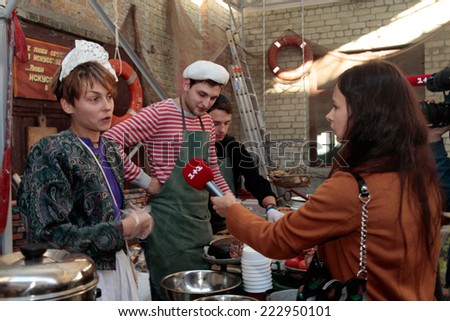 KIEV, UKRAINE - OCTOBER 11, 2014: Unidentified people cook and trades traditional dishes of Odessa restaurant on food stall and giving away TV interview  in Street Food Festival in Kiev, Ukraine.