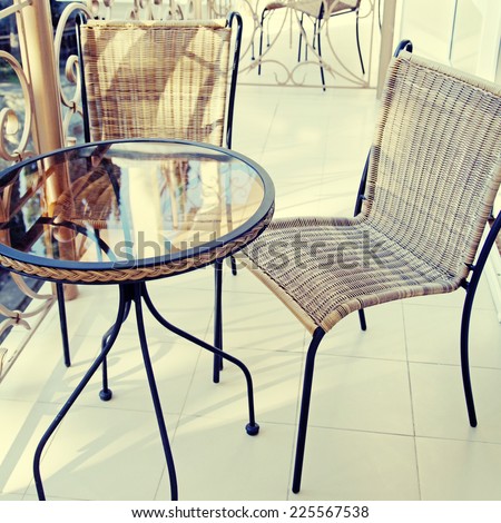 Iron table and chairs on summer resort balcony, square toned image, instagram effect