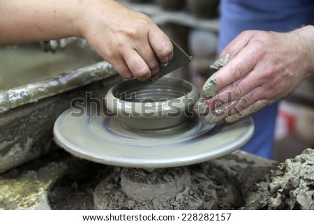 LASSITHI, GREECE - JULY 17, 2012: Potter shaping a bowl on a pottery wheel in Lassithi village, Greece. Potter\'s hands working on clay bowl. Motion blur.