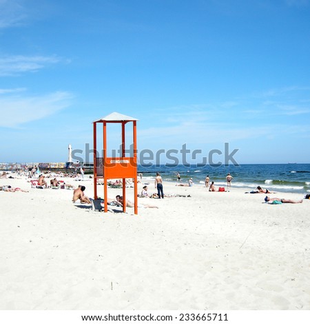 ODESSA, UKRAINE - MAY 3, 2010: People and lifeguards place on the public sand beach Arcadia near Black Sea in Odessa, Ukraine. Square image