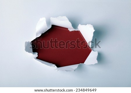 Round hole in paper with red background inside