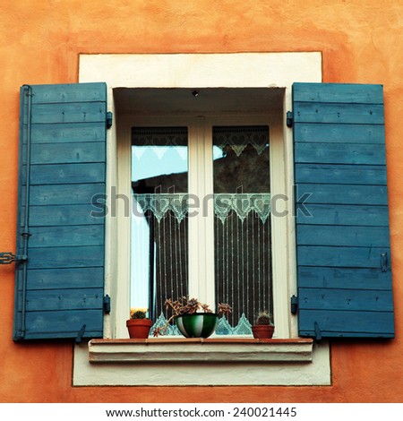 old french open window with blue shutters in red rural house, Provence, France. square toned image, instagram effect