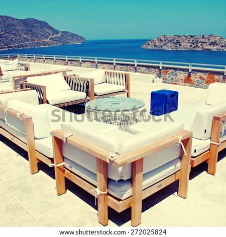 Terrace sea view with outdoor lounge furniture in a luxury resort, Crete, Greece. Square toned image, instagram effect