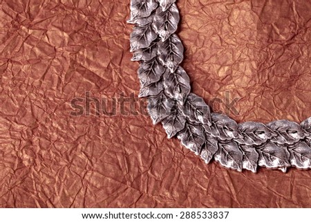 round silver leaves ornament on gold crumpled tissue paper texture for background
