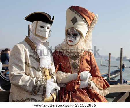 VENICE, ITALY - FEBRUARY 8, 2015: Unidentified persons in Venetian mask and romantic costumes at St. Marco Square, Carnival of Venice, Italy