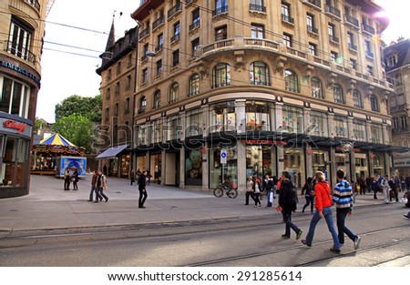 GENEVA, SWITZERLAND - MAY 10, 2013: People walking on main shopping street Rue du Marche, main shopping street in the center of Geneva. Sun beams