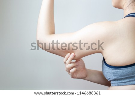 Women show her fat arm close up isolated on white background.  Concept of unhealthy lifestyle.