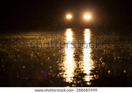 Yellow headlight and road in the dark while heavy raining.
