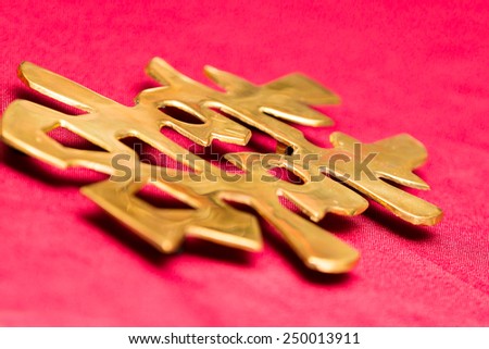 A golden cutout of Chinese Double Happiness character on red, for wedding.