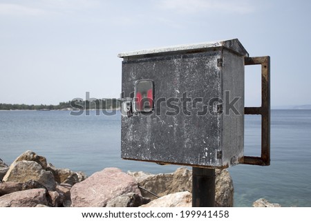 Old electric power box on sea dock