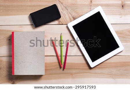 Workplace with digital tablet, cell phone and notebook