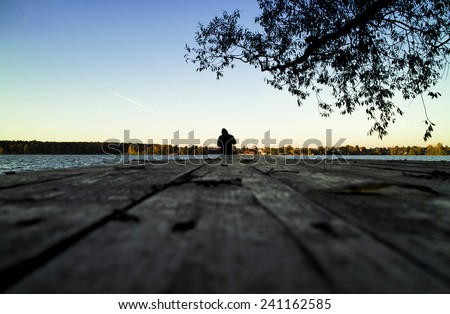 Lone fisherman sunset pier