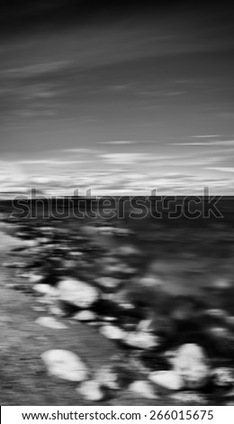 Vertical black and white dramatic stony beach motion blur abstraction background backdrop