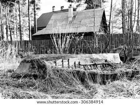 Horizontal black and white house of fisherman with old boats background