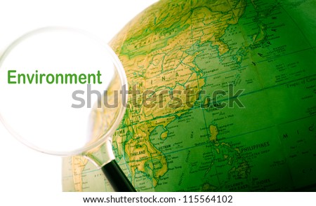 A green globe with a magnifying glass looking at the word environment