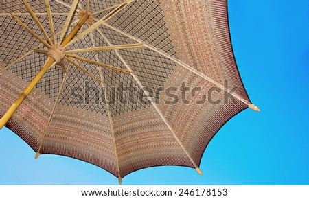 Thailand pattern silk umbrella and sky blue art artist handicraft beach.