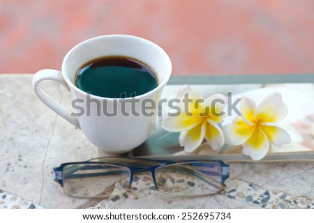 cafa espresso on old table flowers book spectacles.