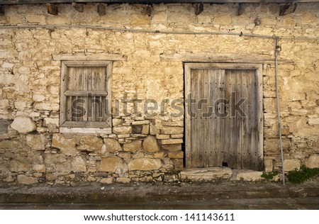 Old stone house with wooden door and window