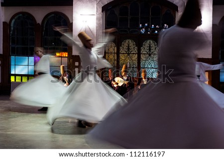 ISTANBUL - OCTOBER 21: Whirling dervishes and musicians perform to visitors in the event hall of Sirkeci Train Station, the old terminus of the Orient Express on October 21, 2005 in Istanbul, Turkey.