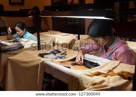 HOI AN, VIETNAM - JANUARY 9: Two unidentified women work on traditional embroideries  on January 9, 2008 in Hoi An, Vietnam. Embroidery has been a traditional handicraft of Vietnam over 700 years.