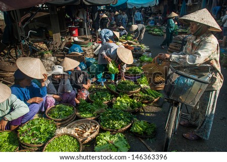 HOI AN, VIETNAM - JANUARY 10: A group of unidentified women sells vegetables in an open market on January 10, 2008 in Hoi An, Vietnam. Agriculture is the most important economic sector in Vietnam.