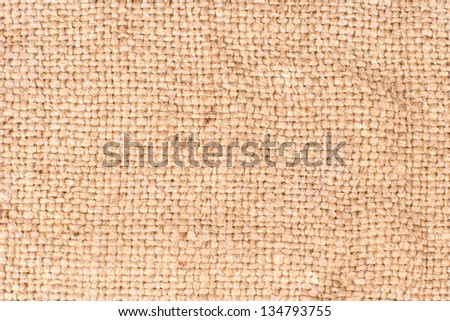 Background texture of a coarse woven fabric or textile with natural fibre and weave pattern detail in a neutral beige colour