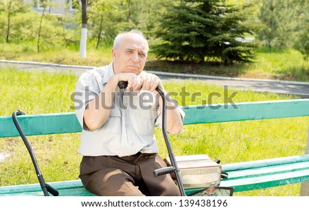 Portrait Of Senior Man Sitting On The Bench Park Waiting For Someone