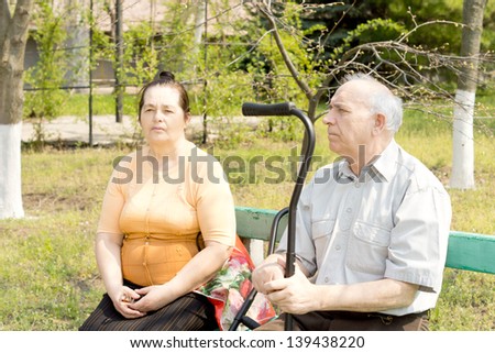 An old man and young woman sitting on the bench park