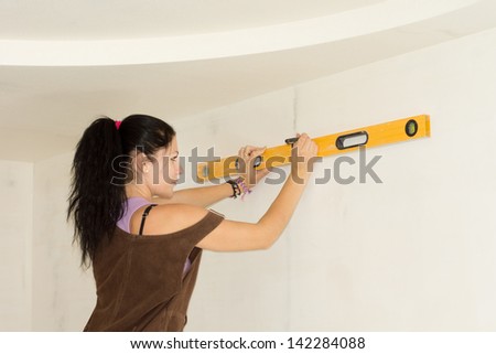 DIY woman using spirit level to work out measurements.