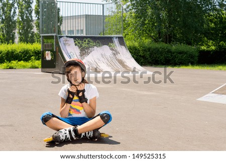 Young girl adjusts her protective head ware before continuing to practice rollerblading