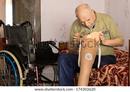 Senior man checking the cup on his prosthetic leg to ensure that there is no dirt adhering to it which might irritate his stump once it is fitted