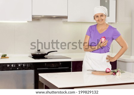 Female cook standing proud with hand on waist in the kitchen