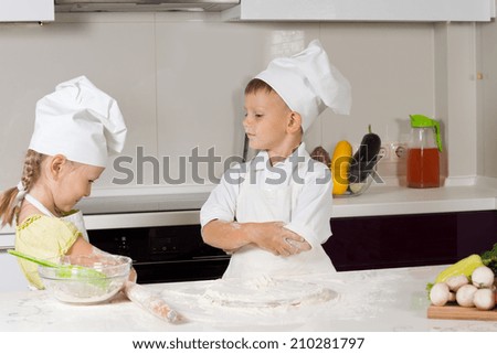 Two Young Cute Chefs Role Playing at the Home Kitchen.