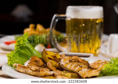 Appetizing Meaty Main Course with Dipping Sauce on Plate and Beer Mug on Side. Ready to Eat for Guest.