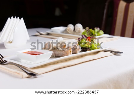 Plates of Spring Rolls Appetizers at Place Settings on Restaurant Table