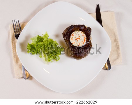 Overview of Steak Topped with Herbed Butter on Plate at Place Setting on Table