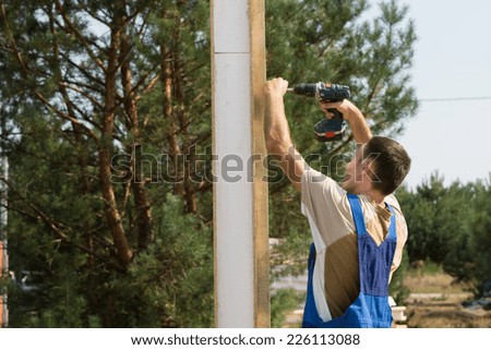 Solo Young Construction Man Using Cordless Drill Device in Building House