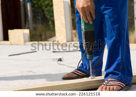 Close up Construction Worker Use a Drill Device in Building a Real Estate House.