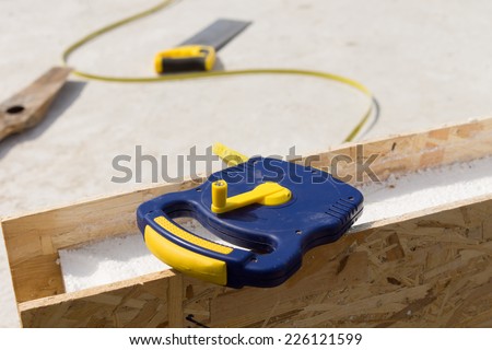 Builders tape measure lying on an insulated wooden wall panel on a construction site, close up view