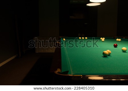 Billiard Balls Scattered on Pool Table in Empty Dimly Lit Pool Hall