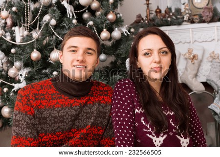 Close up Young White Couple in Casual Long Sleeve Winter Shirt in Front of Christmas Tree Decoration with Various Ornaments.