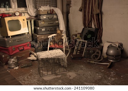 Assorted Junked Old Items in an Old Room with Luggage, Cage, Television and Other Items.