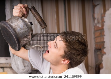 Close up Young Handsome Man Drinking From Vintage Kettle Inside a Room.