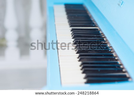 View along a blue piano keyboard with the lid open to display the ivories of the keys conceptual of entertainment and a classical performance