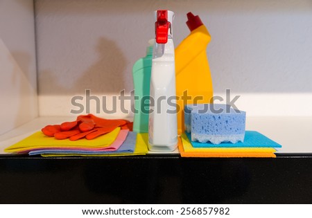 Conceptual image of hygiene and cleanliness in the house with a display of brightly colored cloths, a sponge rubber gloves and spray bottles on a kitchen counter