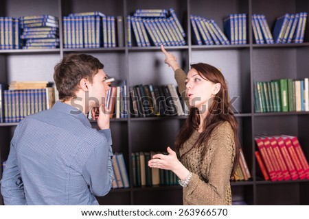 Close up Young White Couple Deciding What Book to Read at the Mini Library
