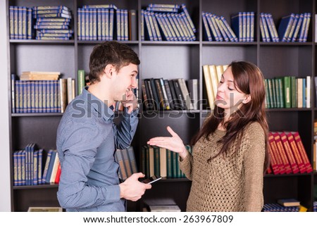 Half Body Shot of Happy Young Lovers Discussing Inside the Library In Front of the Bookshelves.