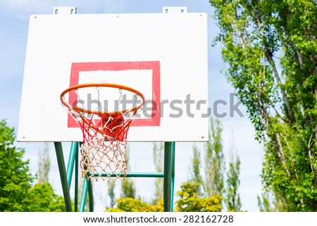 Low Angle View of Basketball Hoop, Basket and Back Board on Outdoor Court Surrounded by Trees