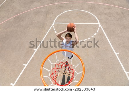 High Angle View from Backboard of Young Athletic Man Making Jump Shot on Net on Outdoor Basketball Court
