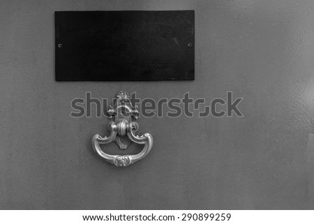 Black and White Detail of Door with Ornate Knocker and Blank Name Plate and Copy Space